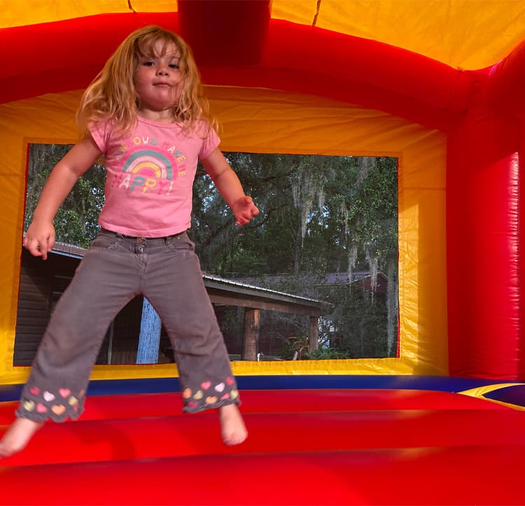 Crayon Craze Bounce House with girl jumping inside
